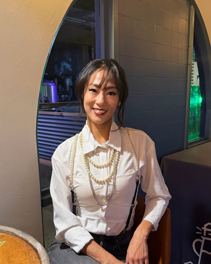 Samantha seated, in a white blouse and pearls