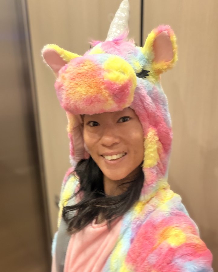 Samantha laughing in a unicorn onesie