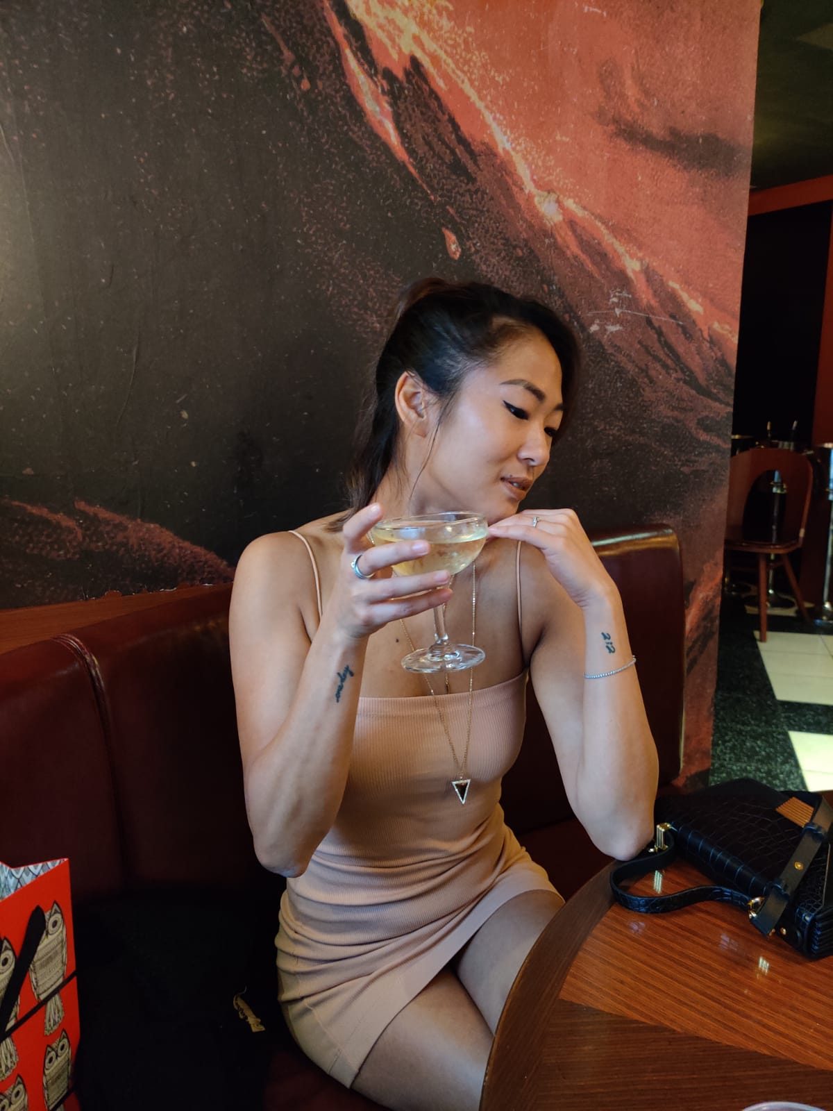 Samantha at a bar with a cocktail